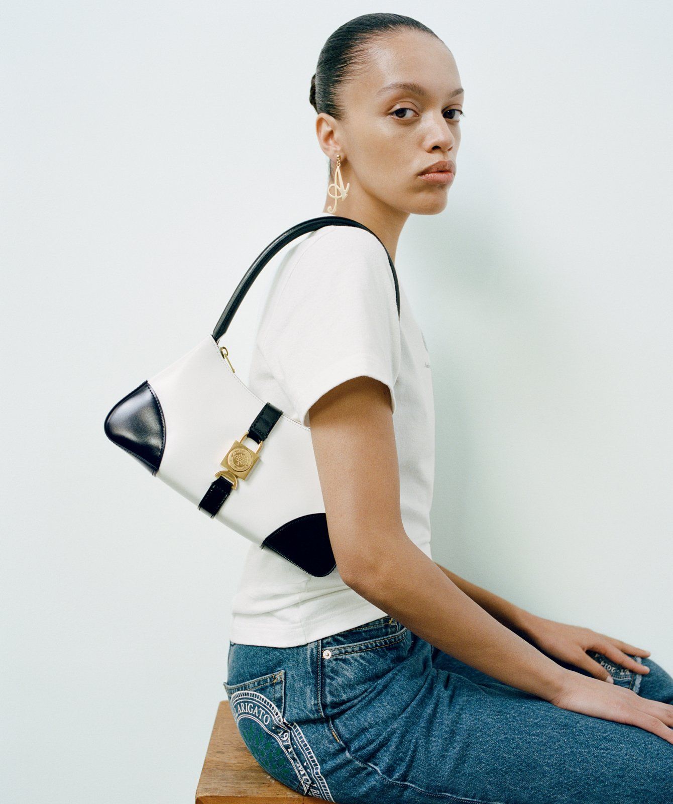 model wearing Axel Arigato for Mulberry Top Handle Bag in black and white
